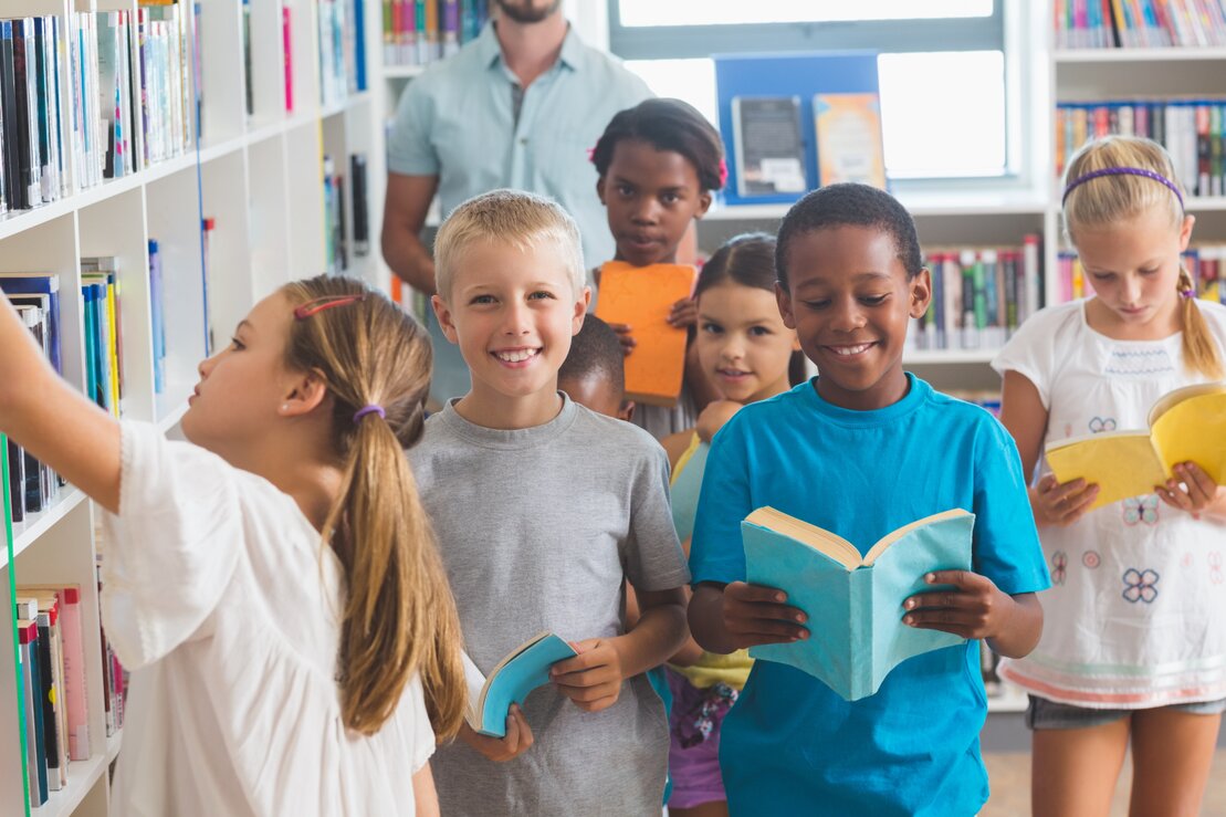 Children raising their hands during a summer reading magic show